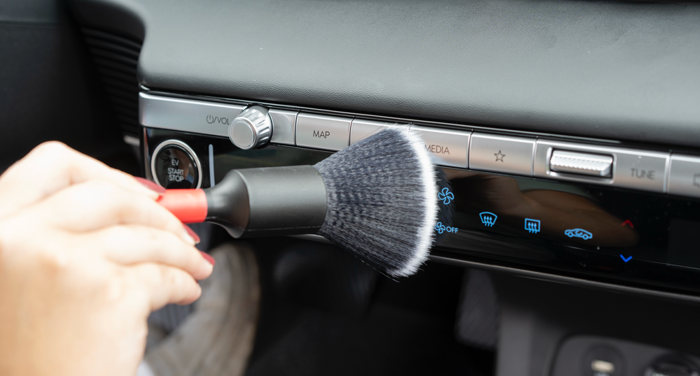 Soft black detailing brush cleaning controls inside a vehicle